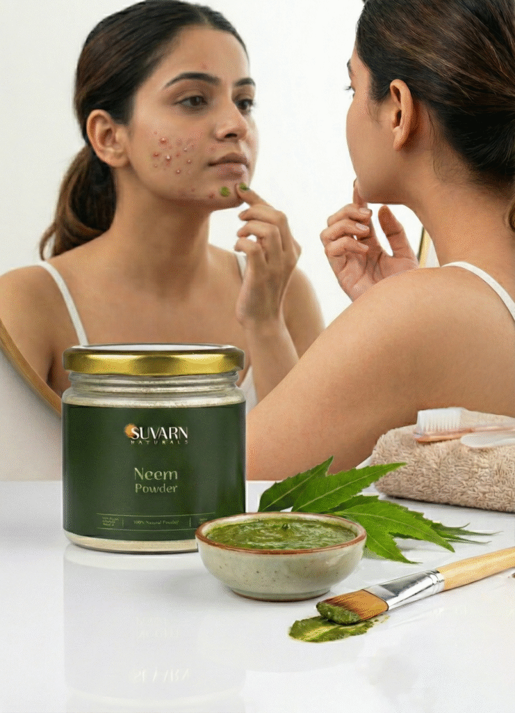 Woman looking at acne in mirror while applying neem paste with Suvarn Naturals neem powder jar and bowl of green paste on counter.