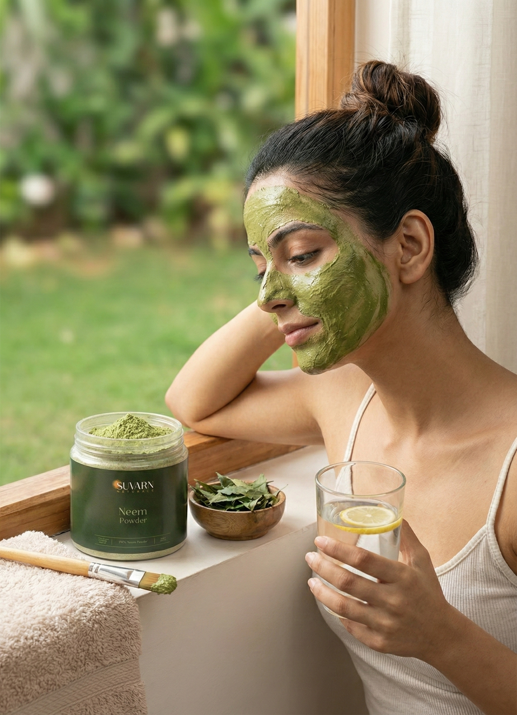 Woman looking at acne in mirror while applying neem paste with Suvarn Naturals neem powder jar and bowl of green paste on counter.